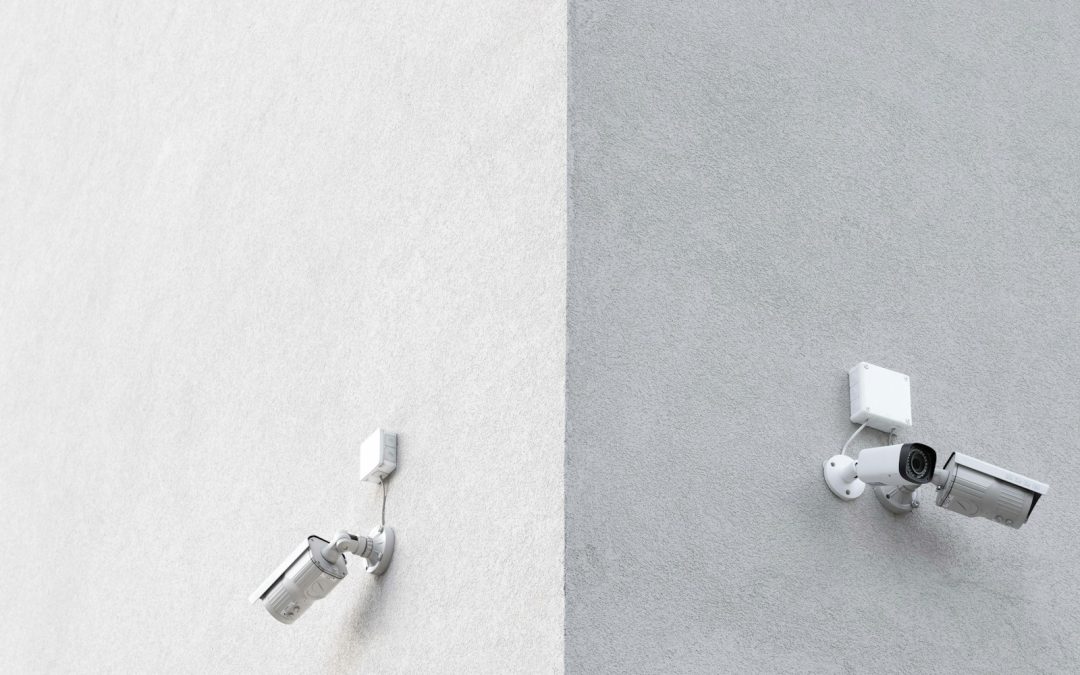 three white CCTV cameras mounted on wall