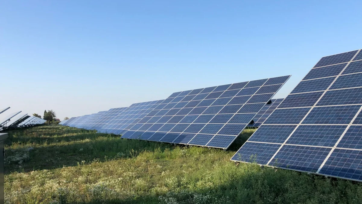 Zonnepanelen in een groen veld onder een heldere blauwe lucht in Tortona, Italië.