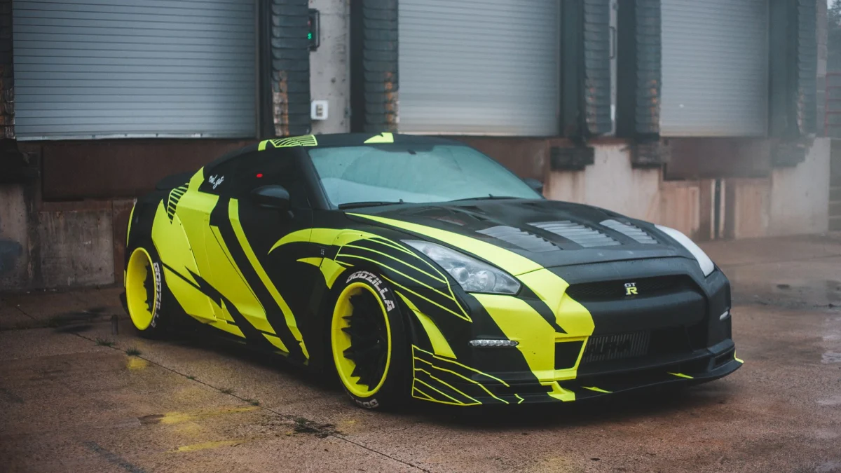 Een slanke zwarte en neon gele sportwagen geparkeerd buiten met moderne ontwerpelementen.